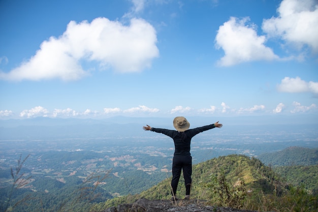 Young man standing on the top of a mountain