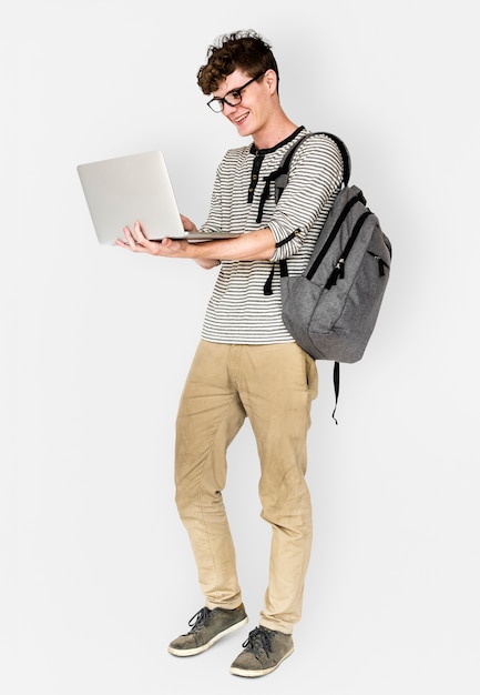 Молодой человек, стоящий, используя подключение к ноутбуку