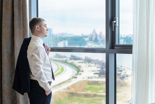 A young man standing at the window