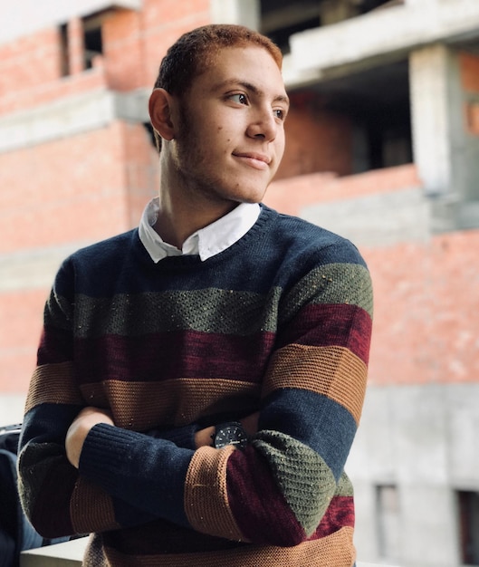 Photo young man standing with arms crossed