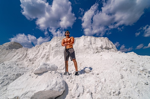 Young man stands on white mountain and looks into the distance