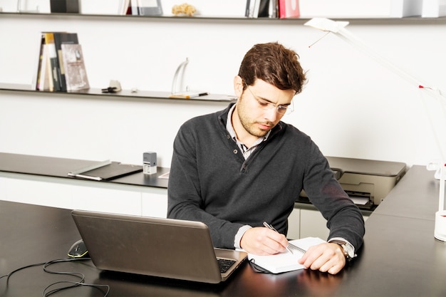 写真 若い男が机の上の作業を開始