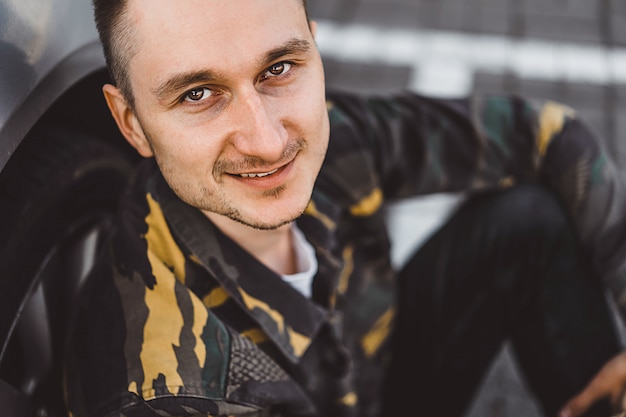 Photo young man street portrait, man in military style.