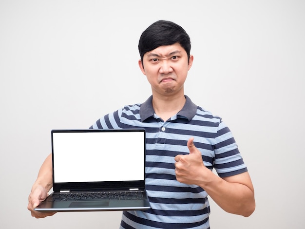 Молодой человек в полосатой рубашке уверенное лицо держит ноутбук с белым экраном и большим пальцем вверх