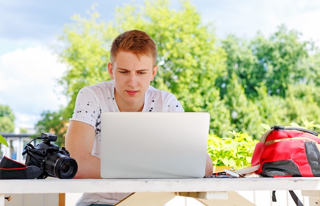 young man student using laptop outside