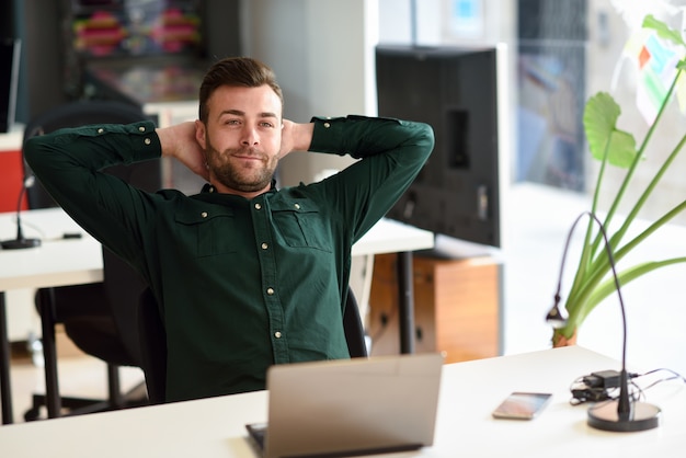 白い机の上でラップトップコンピュータで勉強する若い男。