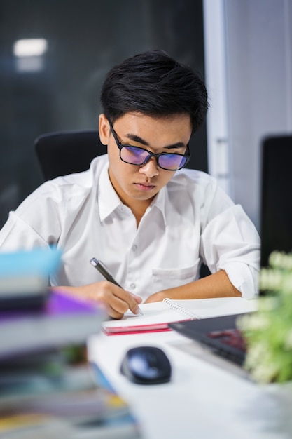 молодой человек, изучающий и пишущий на ноутбуке с ноутбуком