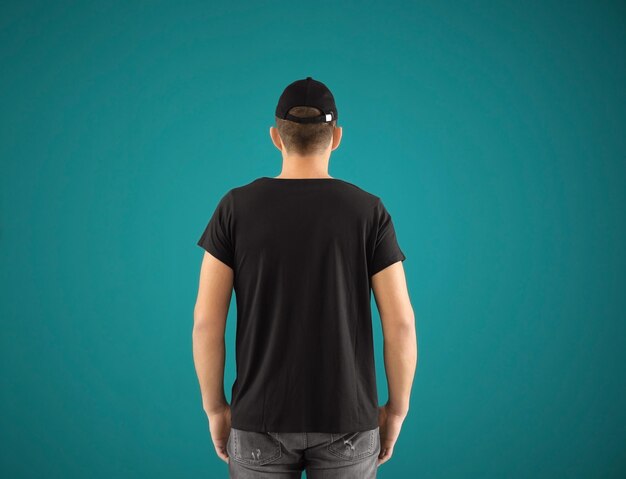 Photo young man in stylish tshirt and cap on color background mockup for design