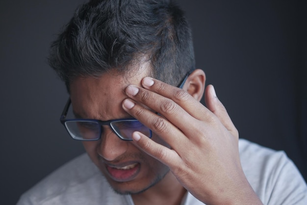 Young man suffering headache close up