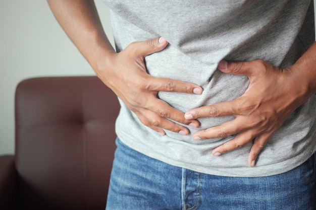 young man suffering stomach pain close up