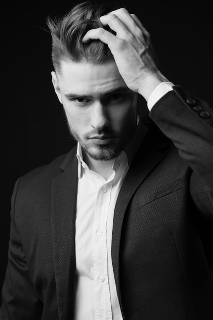 a young man in a suit. the man with the beard. Stylish Male portrait on a black background. black and white photo. male model. studio portrait. The guy in the classic suit