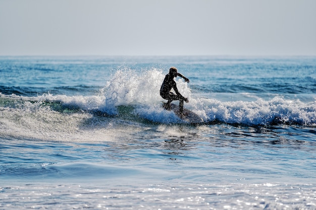 young man surfing the waves on the Pacific Ocean