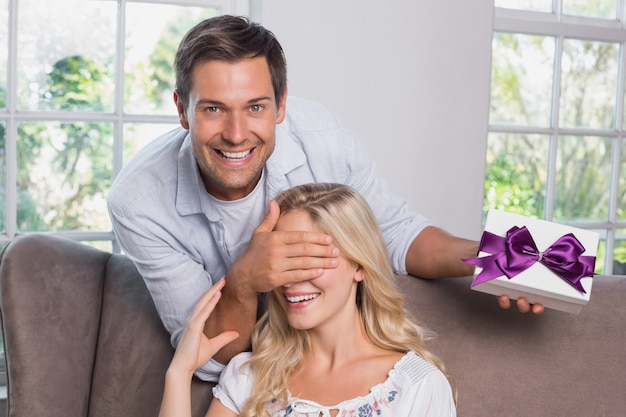 Young man surprising woman with a gift