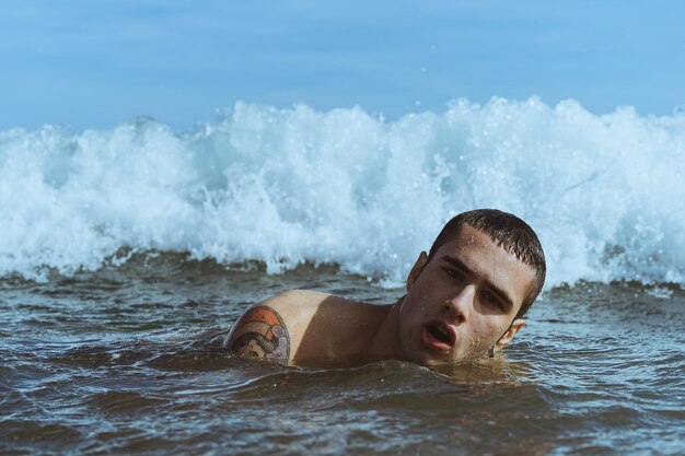 写真 れる海で泳ぐ若い男