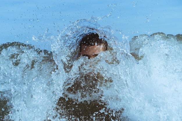 れる海で泳ぐ若い男