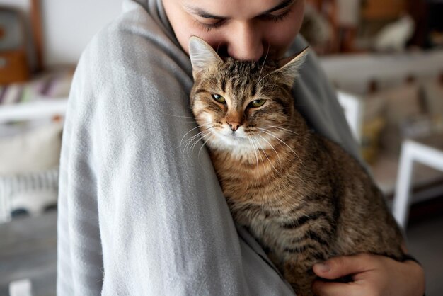 猫を抱いてTシャツを着た若い男。