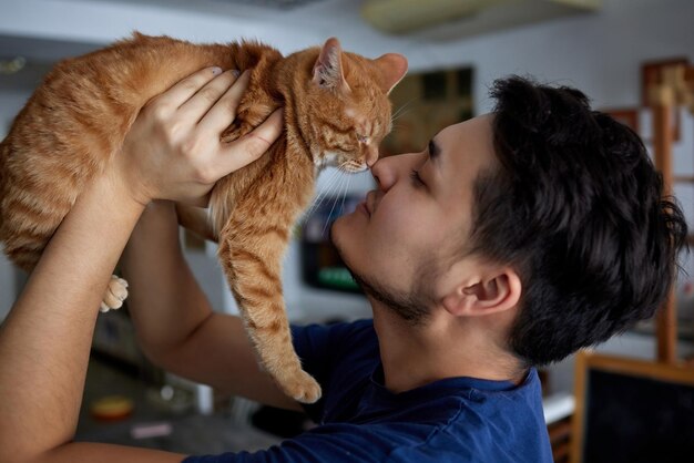 Young man in t shirt holding a cat