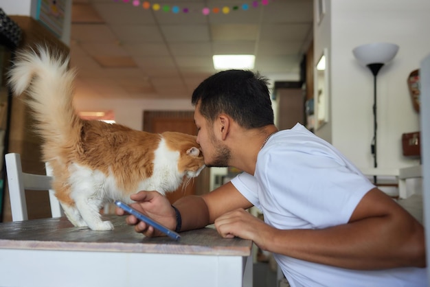 猫を抱いたTシャツを着た若い男