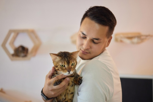 Young man in t shirt holding a cat