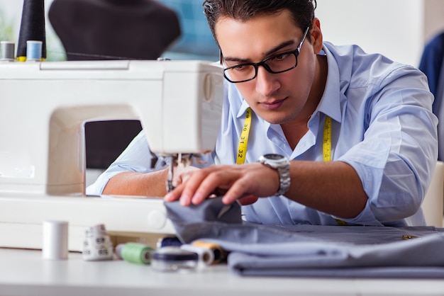 Young man tailor working on new clothing