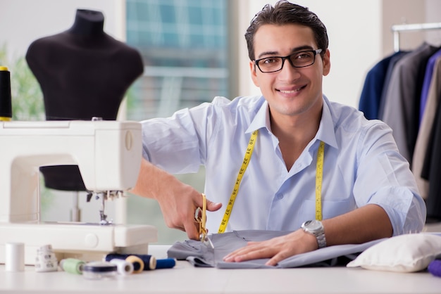 Young man tailor working on new clothing