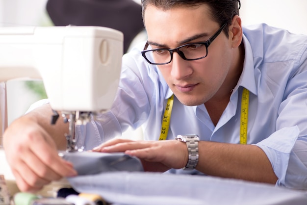 Young man tailor working on new clothing