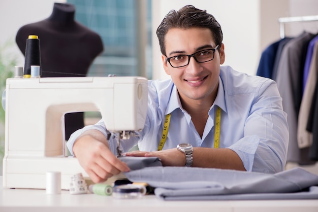 Photo young man tailor working on new clothing