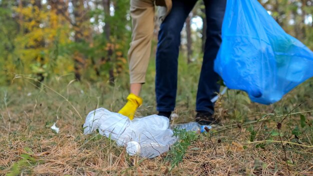 Young man takes action collecting garbage in forest