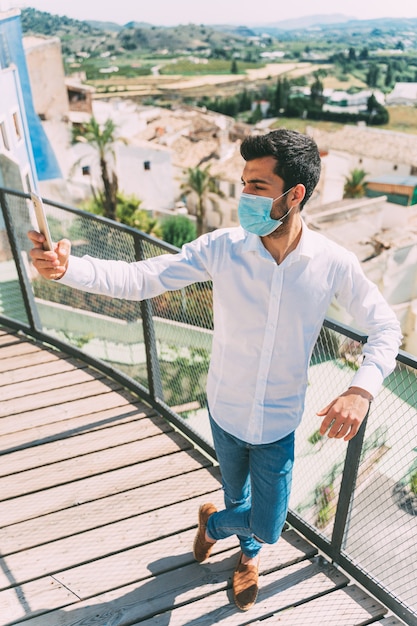 Young man takes a picture with a medical mask on, tourism in Curentena