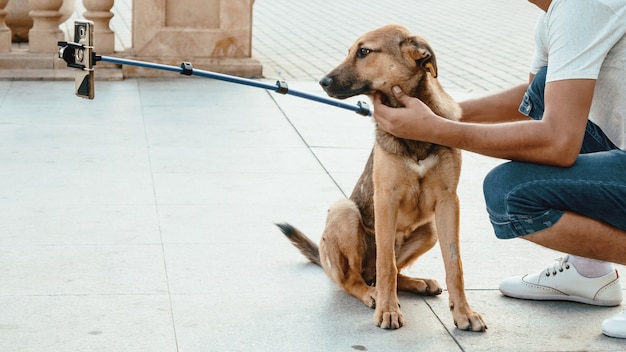 若い男は通り犬とselfieを取る