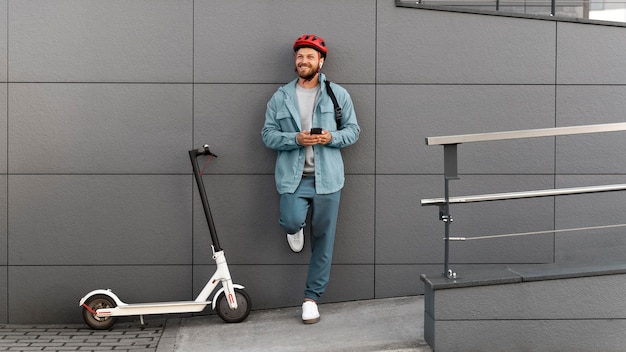 Photo young man taking a break after riding his scooter outside