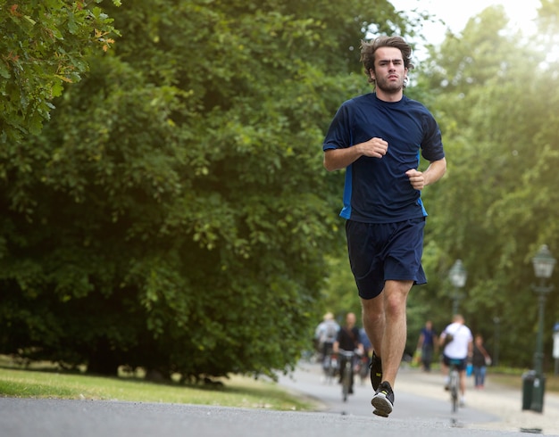 Young man taking casual jog in city park