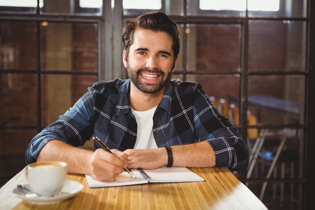 Young man taking notes in his notebook