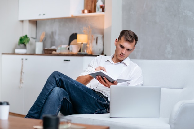 Young man taking notes sitting on the couch . photo with a copy-space.