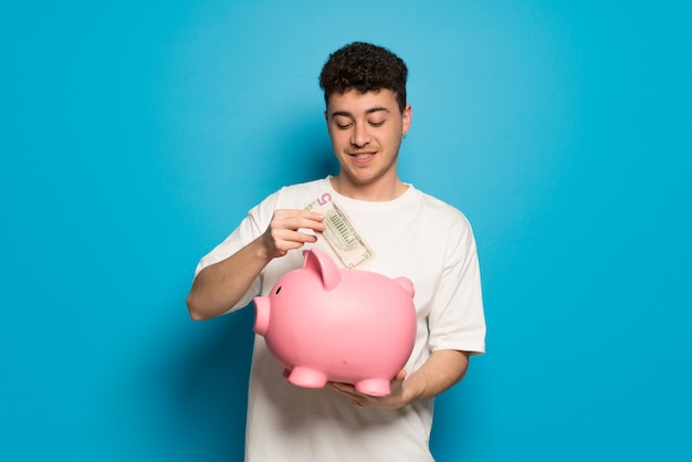 Young man taking a piggy bank and happy because it is full