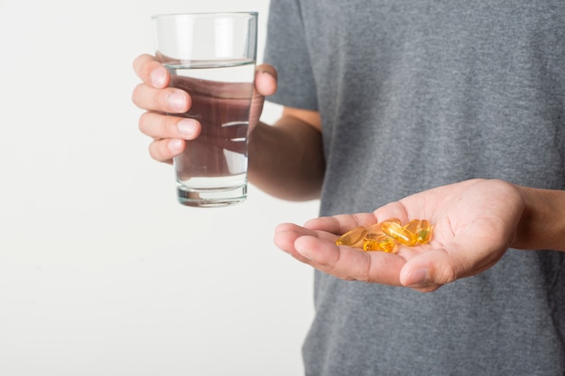 young man taking pill on white background