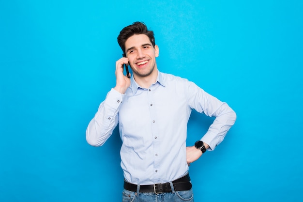 Young man talking on phone against blue space