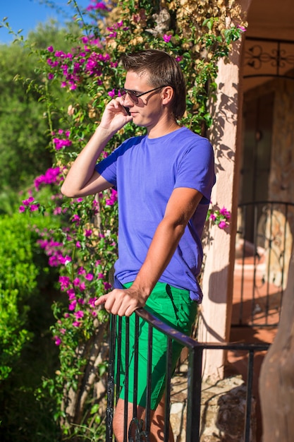 Young man talking on the phone at the balcony