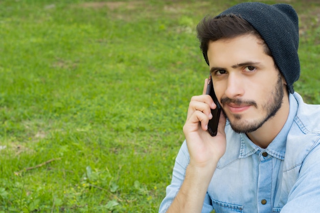 Young man talking on the phone Outdoors.