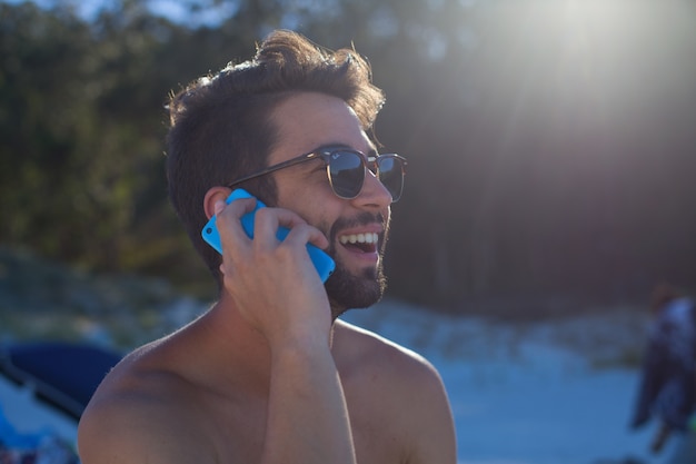 young man talking on telephone in the beach