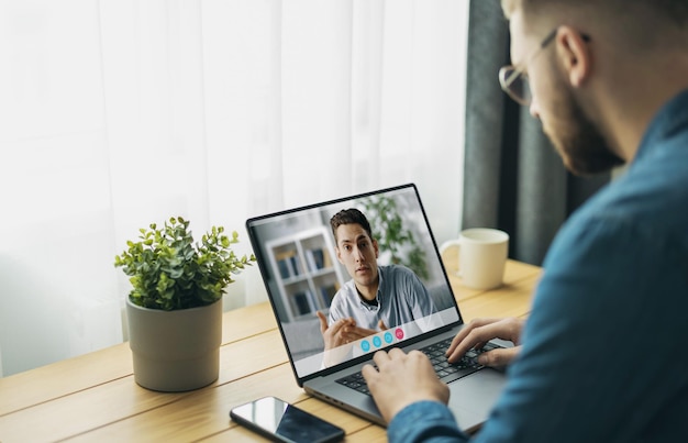 Young man talking using videochat laptop