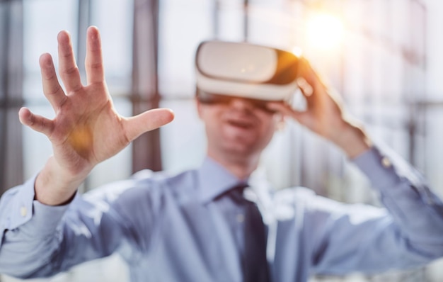 Молодой человек тестирует очки виртуальной реальности или очки, сидя в офисе