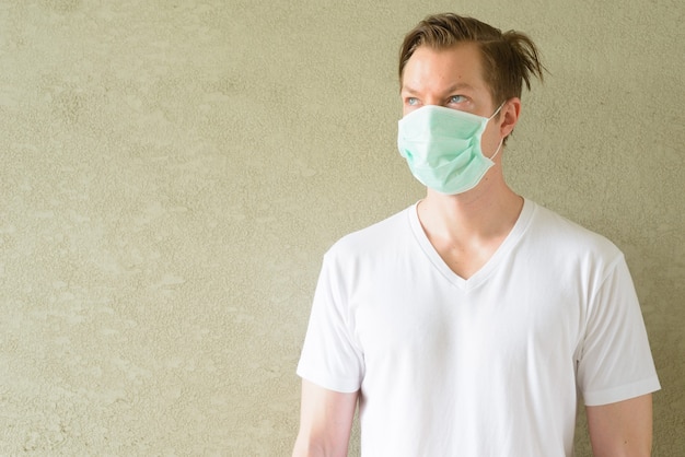 Young man thinking and wearing mask for protection from corona virus outbreak