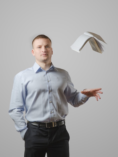 A young man throws the book over his head. On a white surface