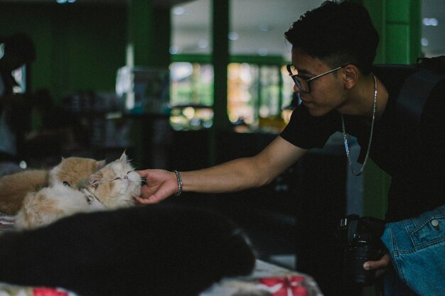 Photo young man touching cat