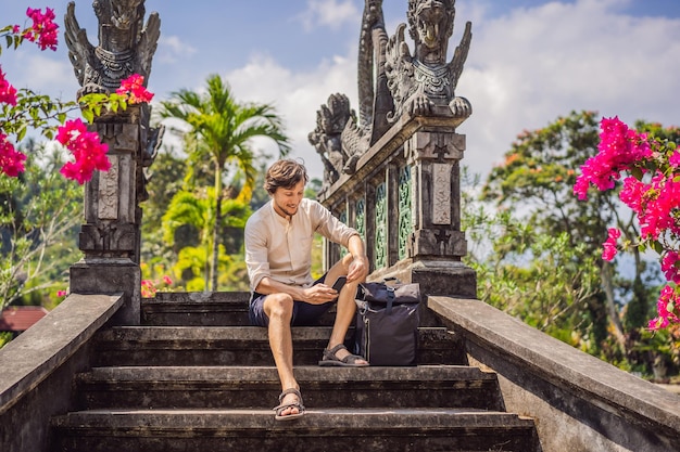 Young man tourist in Taman Tirtagangga Water palace Water park Bali Indonesia