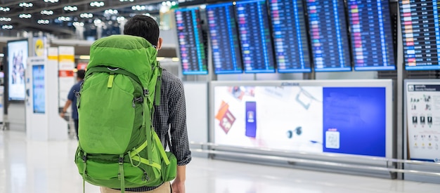 Young man traveler with backpack checking flight time