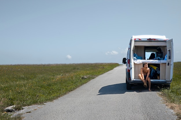 Foto giovane che viaggia da solo in un furgone