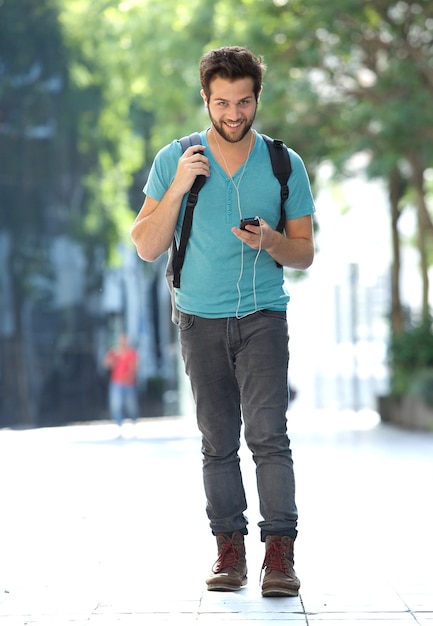 Young man traveling with bag and mobile phone