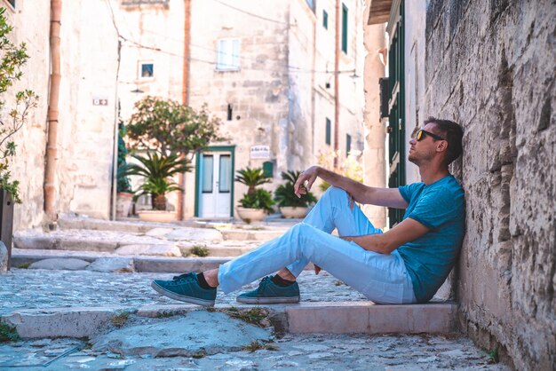 Young man, traveller, exploring Matera old town in province of Matera, Basilicata Region, Italy. Beautiful medieval city.